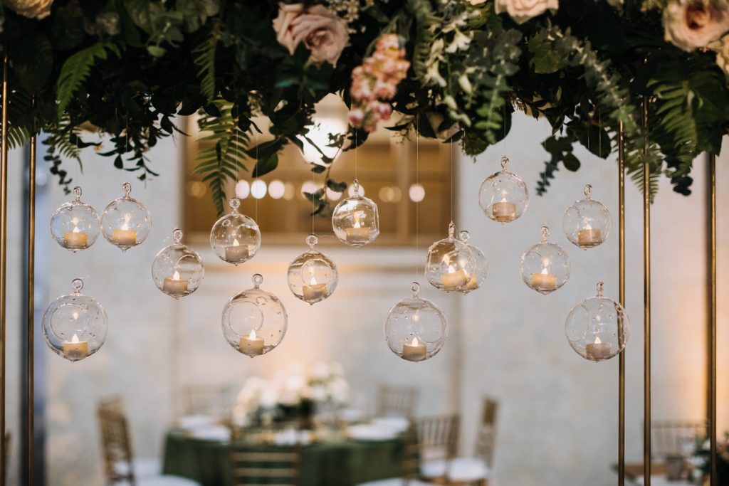 Boho Garden Summer Wedding long table centerpiece featuring garden roses, blushing bride protea, astrantia, spray roses, phlox and eucalyptus on metal stands with hanging candles at the Barnes Foundation. designed by Sebesta Design. Photography by Love Me Do Photography