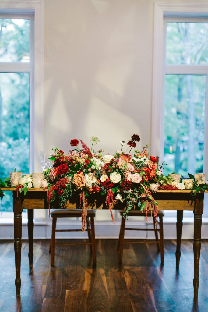 Elegant, Ethereal and Autumnal Pomme Radnor Wedding Reception. Sweetheart Table centerpiece composed of garden roses, tardiva hydrangea, anemones, spray roses, lisianthus, dahlias, hanging amaranthus, garden greenery and touches of smilax vine. Designed by Sebesta Design, Photography by Redfield Photography