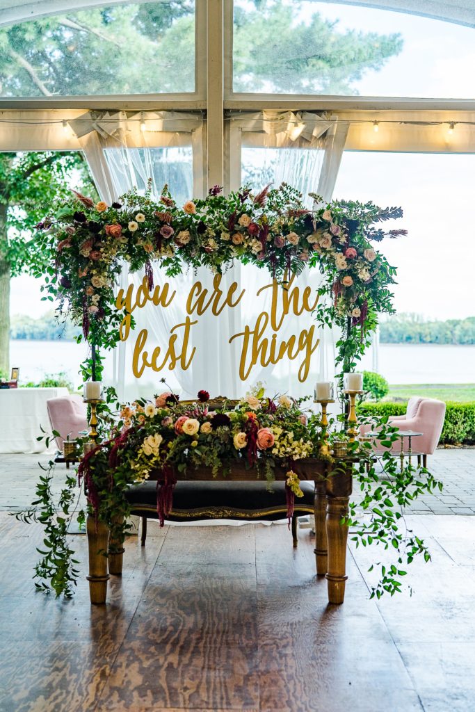 Bold Boho Organic Wedding Reception custom “You Are The Best Thing” sweetheart backdrop covered in flowers at Glen Foerd on the Delaware designed by Sebesta Design and Photographed by The Caffeinated Photographer.
