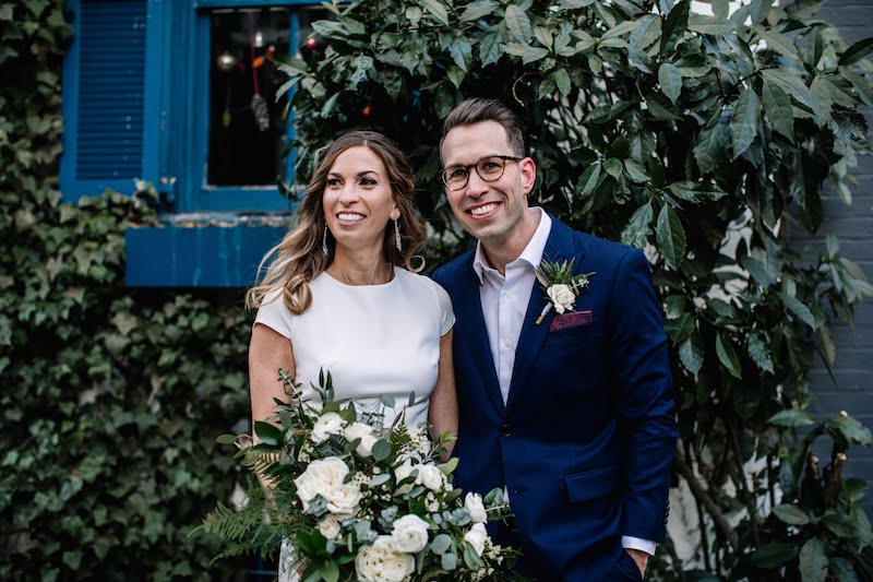 Bride and groom smile with bouquet on wedding day in Philadelphia