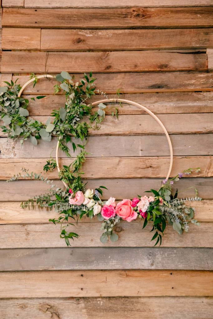 Hanging floral wreaths with romantic antike garden roses, baroness garden roses, eucalyptus, jasmine vine, peach stock decorating the walls at Terrain by Sebesta Design.