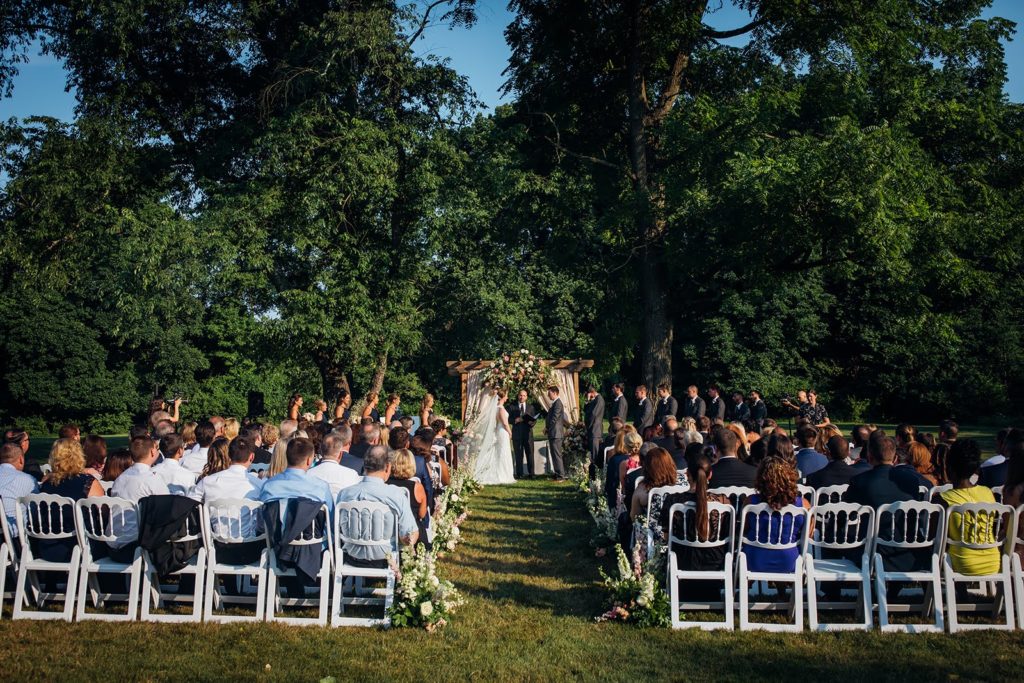 Elegant Secret Garden Outdoor Wedding Ceremony with beautiful decorated floral arch and garden-inspired floral aisle decor outdoors at The Inn at Barley Sheaf Farm by Sebesta Design. Photography by Juliana Laury Photography
