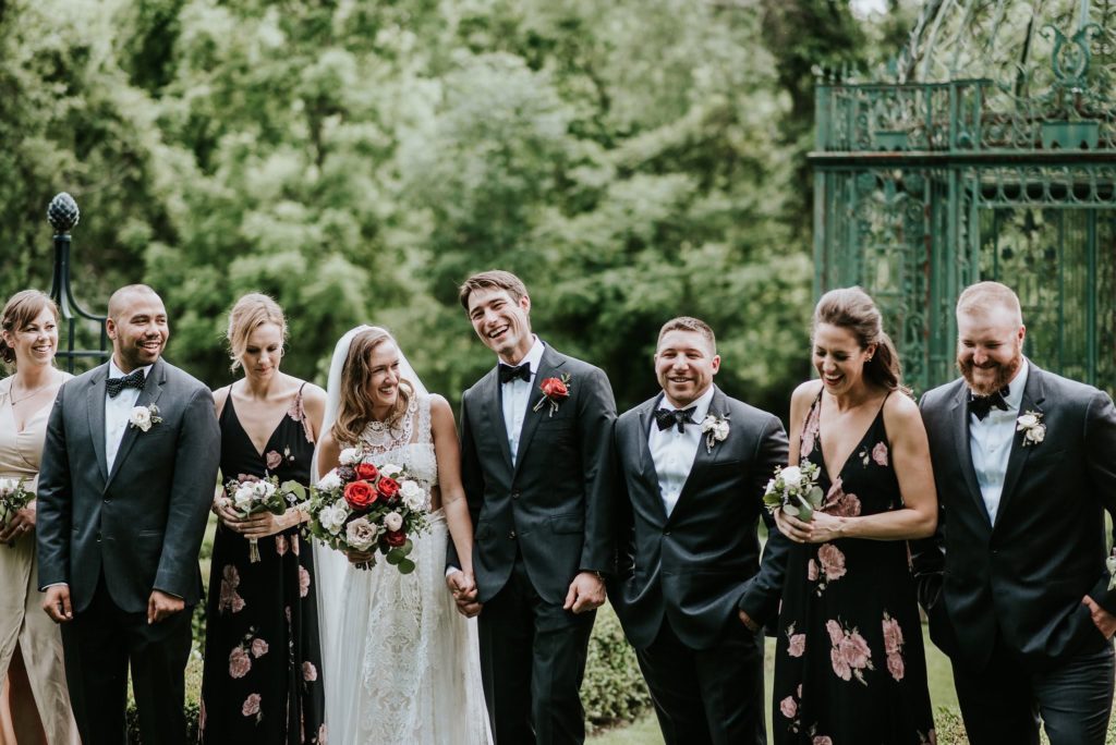 Bridal Party outdoors at Inn at Barley Sheaf Farm. Bride carrying her garden-inspired old world romantic bouquet with specialty mauve-red roses, garden roses, spray roses and mixed eucalyptus greenery designed by Sebesta Design. Photography by M2 Photography.