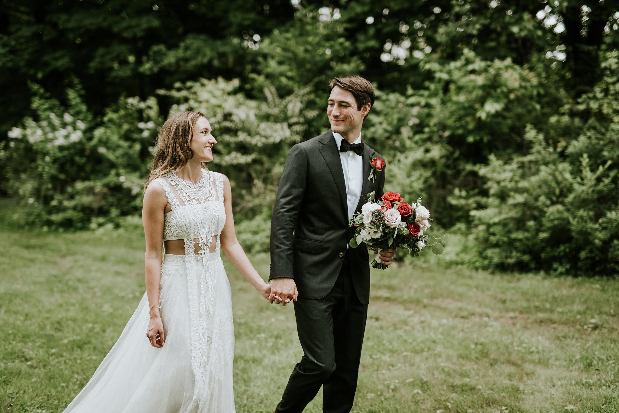 Bride and Groom outdoors at Inn at Barley Sheaf Farm. Bride carrying her garden-inspired old world romantic bouquet with specialty mauve-red roses, garden roses, spray roses and mixed eucalyptus greenery designed by Sebesta Design. Photography by M2 Photography.