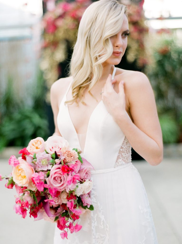 Love is in the Air styled shoot and bespoke bridal event at the Horticulture Center, Model wearing Limor Rosen and carrying a beautiful pink bridal bouquet with sweet peas, roses and garden roses . Event design and florals by Sebesta Design. Photography by Emily Wren Photography. 