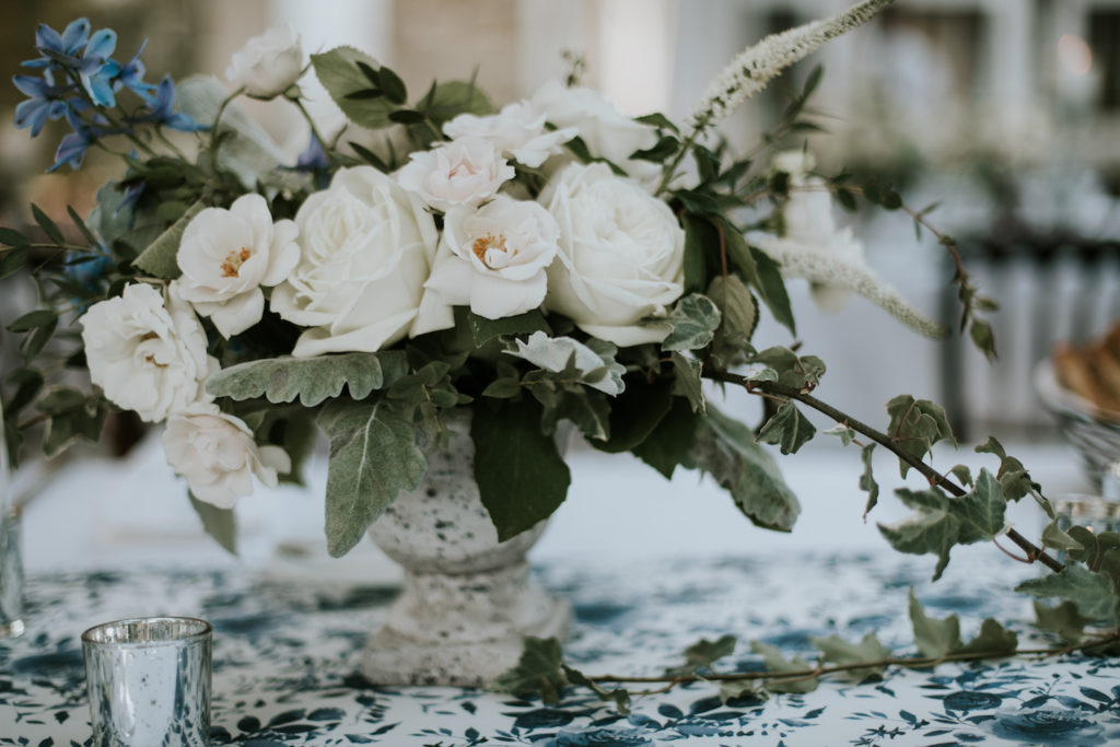 Spring English Garden Welkinweir Wedding Reception. Long table centerpiece in a stone urn featuring peonies, hydrangea, white majolica spray roses, lysimachia, lisianthus, delphinium, garden greens and ivy. Designed by Sebesta Design, Photography by M2 Photography.