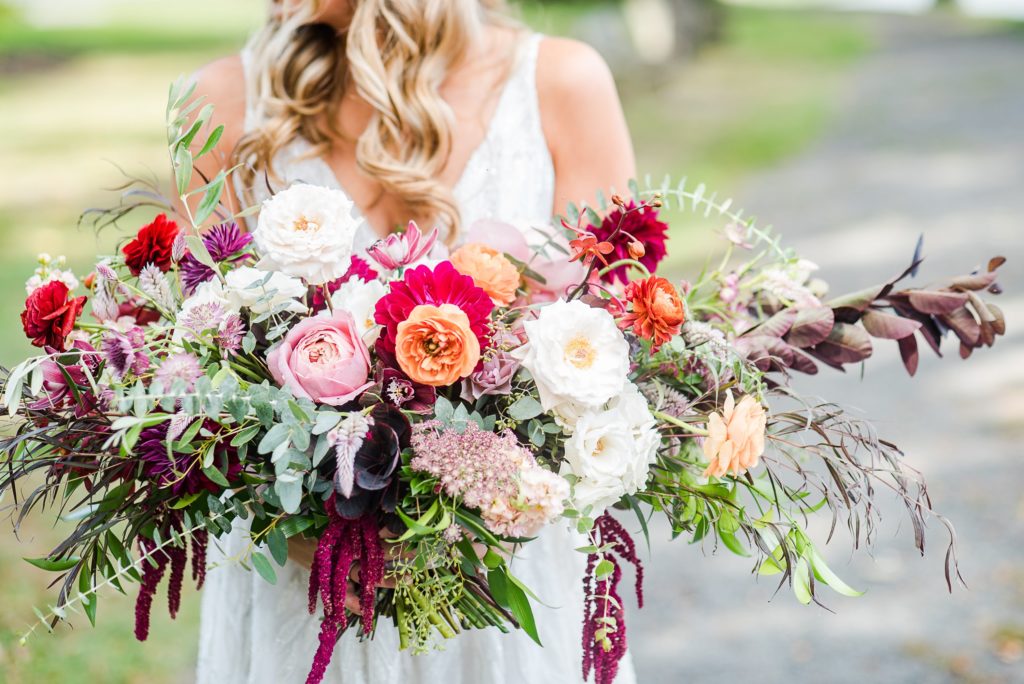 Bold Boho Organic Bridal Bouquet featuring orchids, garden roses, dahlias, chocolate lace flower, spray roses, ranunculus, plume celosia, hanging amaranthus and garden foliage designed by Sebesta Design. Photographed by The Caffeinated Photographer.