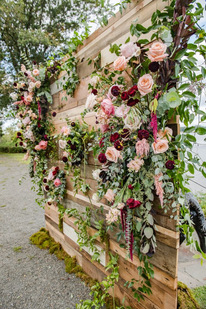 Bold Boho Organic Wedding custom reclaimed wood pallet ceremony backdrop covered in flowers, designed by Sebesta Design and Photographed by The Caffeinated Photographer. 