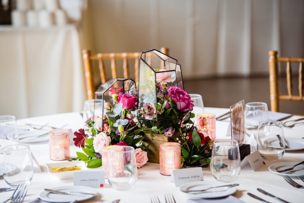 Fun Pink Garden wedding reception centerpiece with flowers, geometric glass terrariums, hand-painted table numbers and blush mercury votive cups at John James Audubon Center by Sebesta Design photographed by Morby Photography