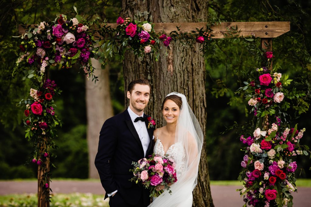 Fun Pink Garden wedding Ceremony with floral arch at John James Audubon Center by Sebesta Design photographed by Morby Photography