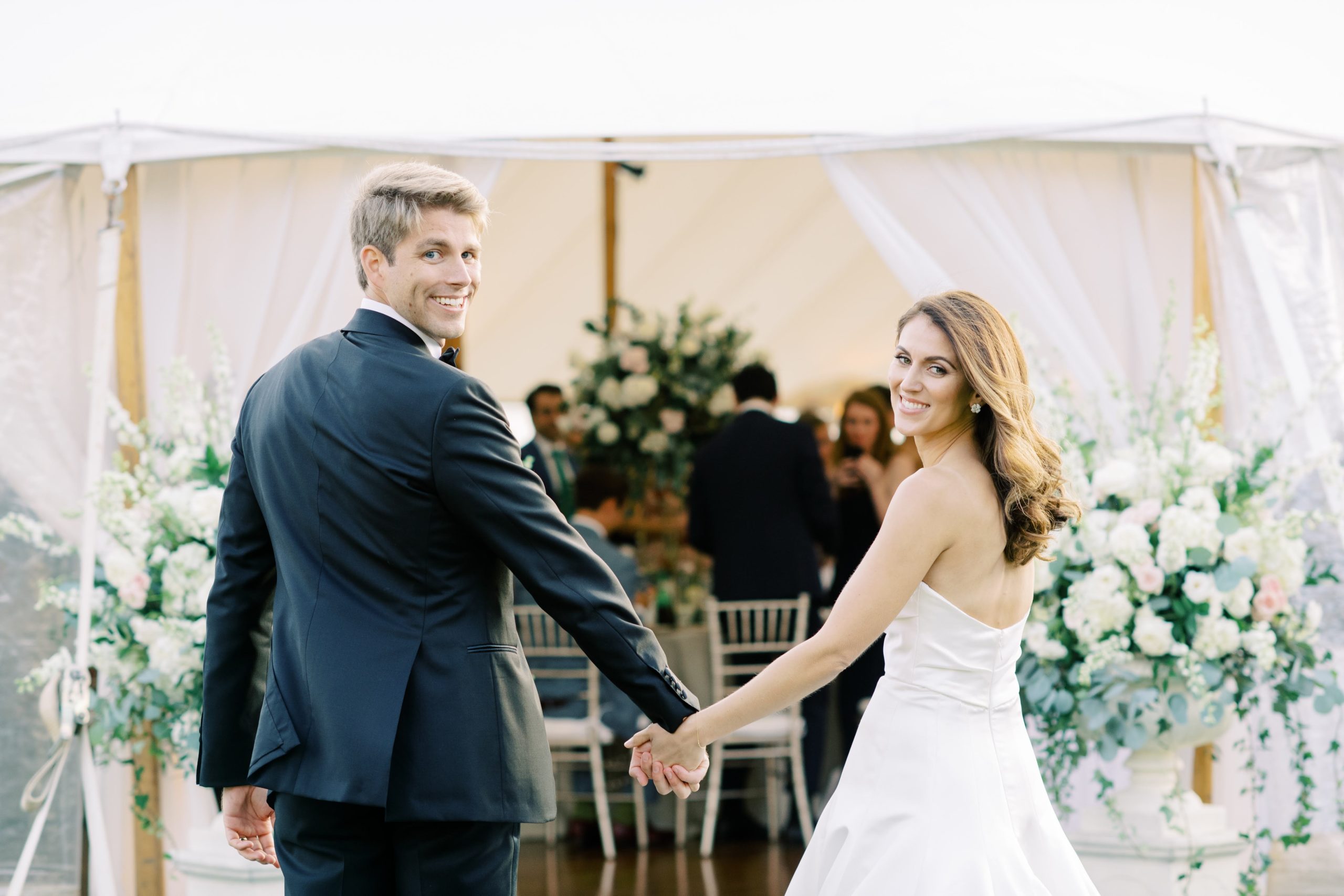 Classic Timeless Garden Party Cape May Congress Hall Wedding. Bride and groom entering Sailcloth tent for lawn reception. entrance flanked by lush overflowing garden urns. Event design by Sebesta design, photography by Rachel Pearlman Photography